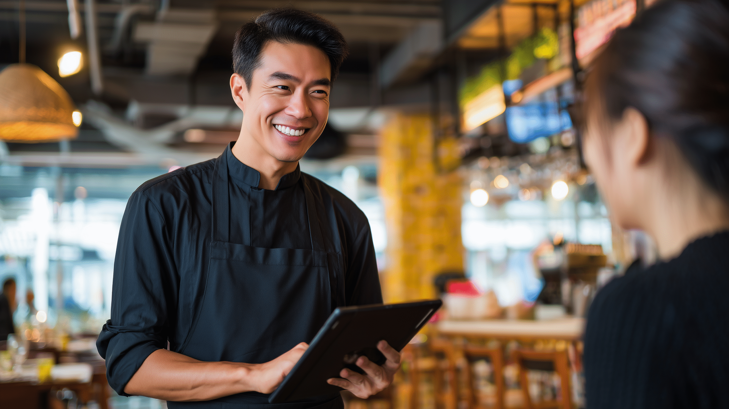 Waiter taking a customers order using a digital tablet